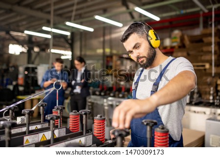Serious Technician Of Processing Factory Setting Technical Equipment 商業照片 © Pressmaster