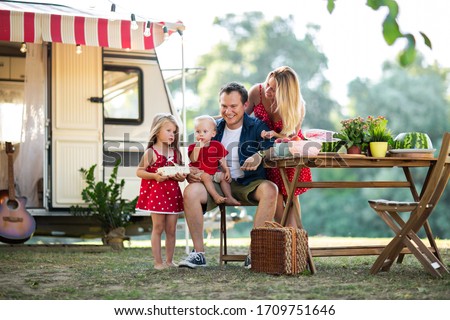 Foto d'archivio: Child Girl In A Short Dress In The Summer Near The Trailer With Freshly Mown Hay