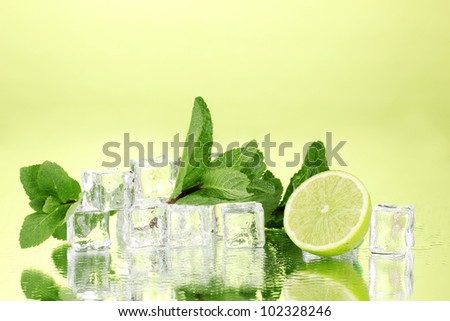 Stockfoto: Fresh Mint Leaf And Ice Cubes With Droplets And Lime On Green Ba