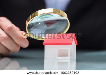 Сток-фото: Businessperson Looking At House Model Through Magnifying Glass