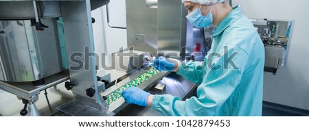 Foto d'archivio: Pharmaceutical Industry Man Worker In Protective Clothing Operating Production Of Tablets In Sterile