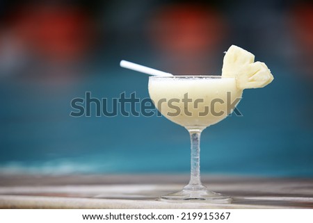 Stockfoto: Glass Of Pinacolada Cocktail Standing On The Swimming Pool Ledge