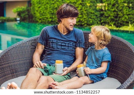 Stok fotoğraf: Father And Son Eat Dessert With Chia Seeds And Mangoes By The Pool In The Morning Healthy Eating V