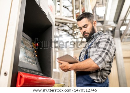 Zdjęcia stock: Bearded Young Worker Of Polymer Production Looking Through Data In Touchpad