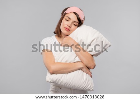 Young Tranquil Female Embracing Pillow While Keeping Her Head On It 商業照片 © Pressmaster