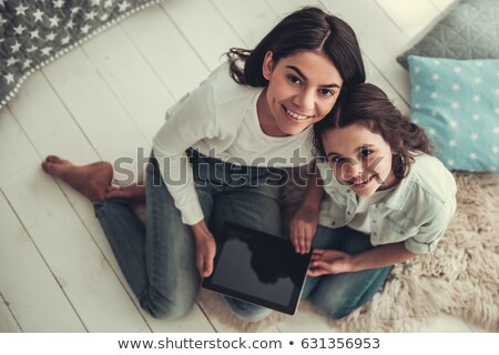 [[stock_photo]]: High Angle View Of Loving Mother And Daughter Using Digital Tablet In Bedroom At Home