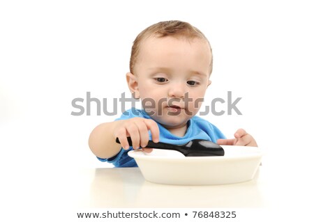 Cute Adorable One Year Old Baby With Green Eyes Eating On Table Spoon And Plate Foto stock © Zurijeta