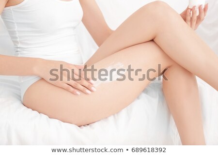 Stok fotoğraf: Woman Smoothing Cream Onto Her Legs