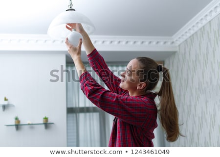 Foto d'archivio: Female Electrician With A Lightbulb