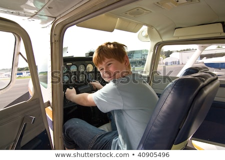 Stock photo: Joung Boy Is Flying Aircraft Assisted By A Trainer