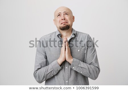 Foto stock: Portrait Of A Handsome Man Praying Over Gray Background