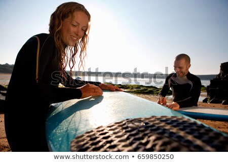 Stock fotó: Couple Waxing Their Surfboards Smiling