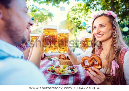 [[stock_photo]]: Couple Clinking Glasses With Huge Amounts Of Beer In Bavarian Pub