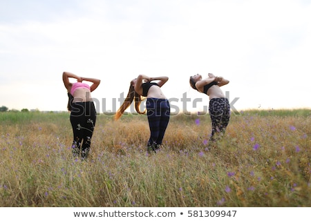 Foto d'archivio: A Woman In The Open Air Dressed In Sportswear Warms Up And Exercises