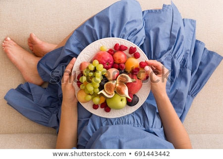 Foto stock: Pregnant Happy Young Woman With Green Apple On Blue Background