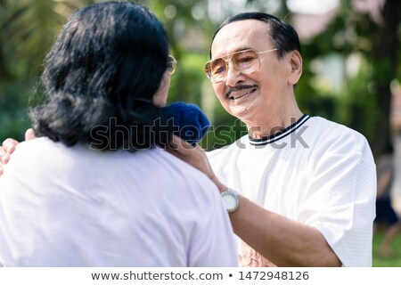 Сток-фото: Smiling Man Wiping Sweat Of His Wife With Napkin