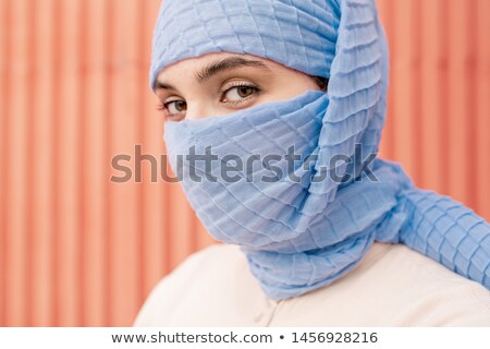 Foto d'archivio: Young Beautiful Arabian Female With Her Face Hidden Behind Blue Hijab