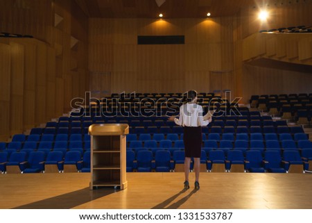 Stockfoto: Rear View Of Blonde Caucasian Businesswoman Practicing And Learning Script While Standing In The Aud
