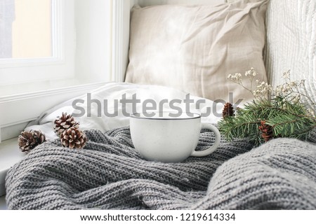 Сток-фото: Comfortable Cushions And White Mug Of Hot Drink In Cozy Living R