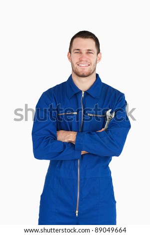 Stock foto: Smiling Young Mechanic In Boiler Suit Holding A Wrench Against A White Background