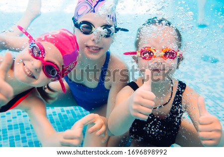 ストックフォト: A Child Boy Is Swimming Underwater In A Pool Smiling And Holding Breath With Swimming Glasses