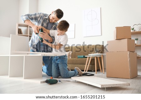 Stock photo: Father And Son Assembling Furniture Boy Helping His Dad At Home Happy Family Concept