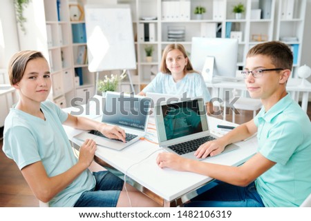 Foto stock: Three Successful Clever Students Of Contemporary Middle School Sitting By Desk