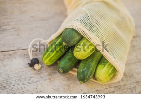 Foto stock: Cucumbers In A Reusable Bag On A Stylish Wooden Kitchen Surface Zero Waste Concept