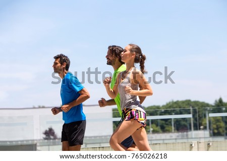 Stok fotoğraf: Two Young Men And Woman Running In Urban Enviroment