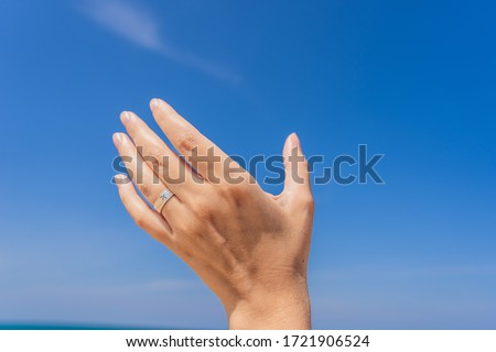 Stock photo: Female Hand With A Ring With A Drawn Plane Holding A Plane Flying In The Sky Traveling On An Airpla