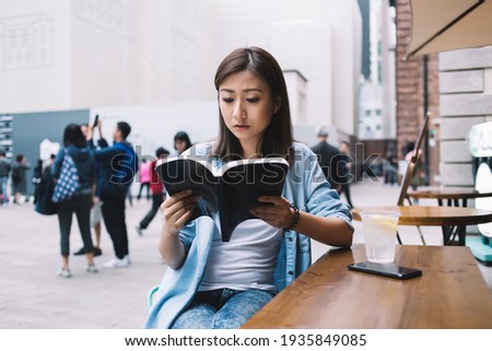 Stock photo: Serious Brunette Asian Female In Smart Casual Reading Documents Before Meeting