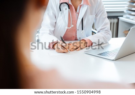 Zdjęcia stock: Close Up Of Doctor Taking Notes While Having Appointment With Patient