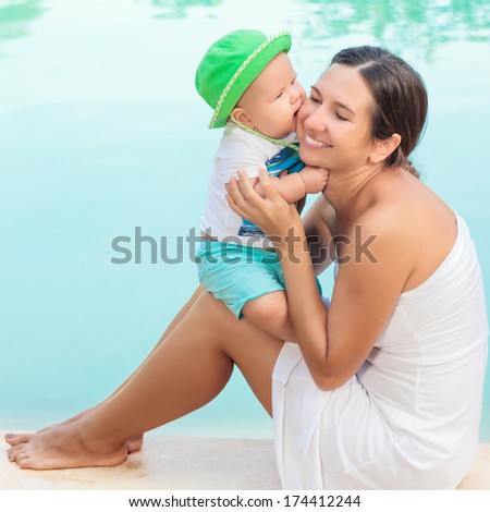 Stock photo: Mom With Young Son On The Edge Of The Pool Sitting On A Chair For Sun Treatments