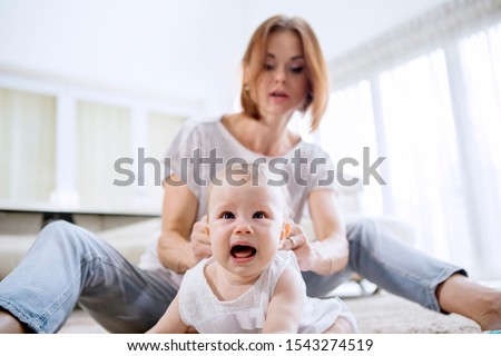 Foto d'archivio: Close Up Shot Of Affectionate Young Mother And Her Little Daughter Touches Noses And Enjoy Togethern