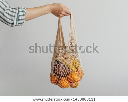 Stock photo: Banana In A Reusable Bag In The Hands Of A Young Woman Zero Waste Concept Plastic Free Concept He