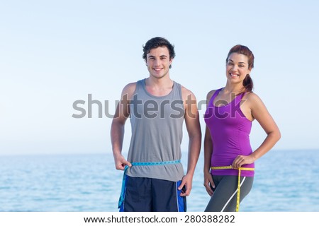 Foto d'archivio: Happy Athletic Couple - Man And Woman With Measuring Tape With T