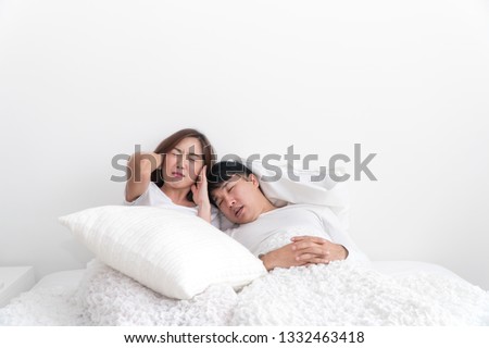 [[stock_photo]]: Young Man Lying On A Bed Covered Her Ears Because Of The Noise In The Window After The Bed You Can