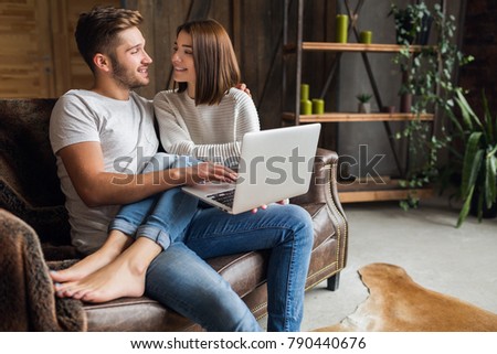 Zdjęcia stock: Lovely Couple Man And Woman Sitting On Sofa In Apartment Near Bi