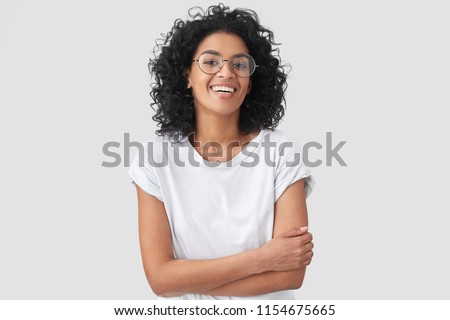 Сток-фото: Indoor Shot Of Attractive Dark Haired Woman Keeps Hands Under Chin Wears Striped Sailor Sweater Op