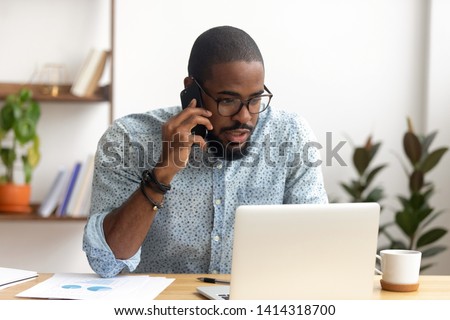 Stock photo: Serious Male Finance Manager Talks On Mobile Phone Solves Problems With Partner Writes Some Notes