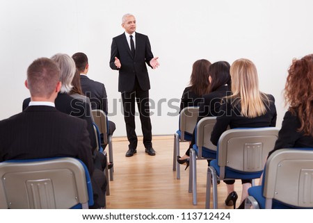 ストックフォト: Smiling Young Businessman Giving A Presentation With His Hands