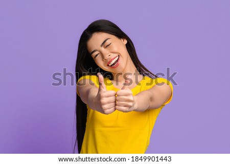 Stockfoto: Smiling Young Asian Woman Showing Thumb Up Sign With Both Hands