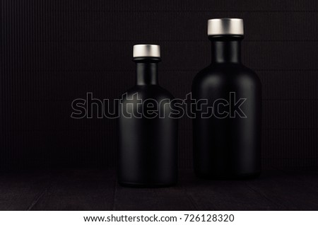Zdjęcia stock: Dark Black Minimalist Interior With Blank Black Bottles White Small Flowers On Dark Wood Board Mo