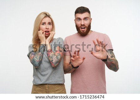 Foto stock: Image Of Scared Man And Woman In Basic Clothing Looking At Each