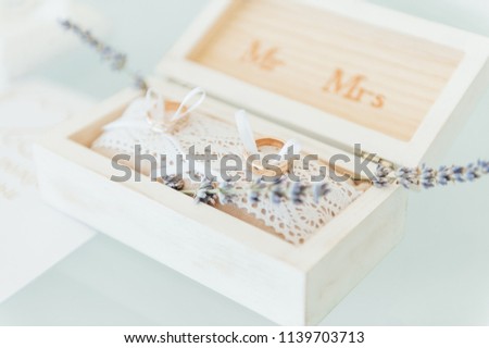 Stok fotoğraf: Side View Shot Of Two Gold Wedding Rings On Flowers In Old Rustic Wooden Box For Wedding Ceremony