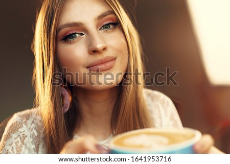 Stockfoto: Pretty Young Smiling Woman Having Glass Of Cappuccino With Cheesecake