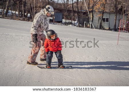 Stok fotoğraf: Dad Teaches Son Snowboarding Activities For Children In Winter Childrens Winter Sport Lifestyle