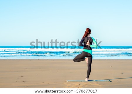 Stockfoto: Young Woman Practicing Yoga On The Beach At Sunset Behind The Ke