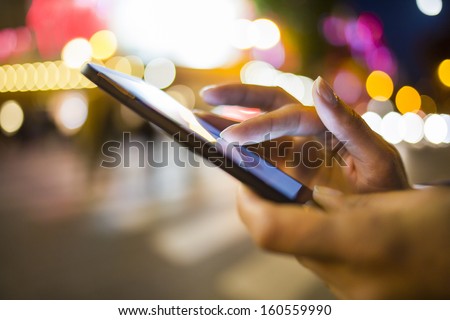 Stock photo: Young Woman Messagingusing An App On Her Smart Phone In A City