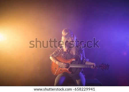 ストックフォト: Confident Female Singer Playing Guitar In Illuminated Nightclub
